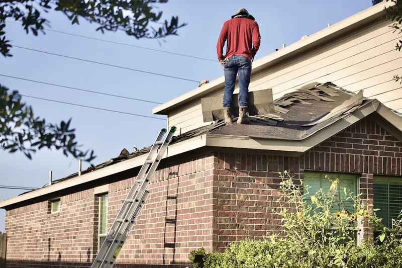 Professional roofer working on a residential roof in Clay